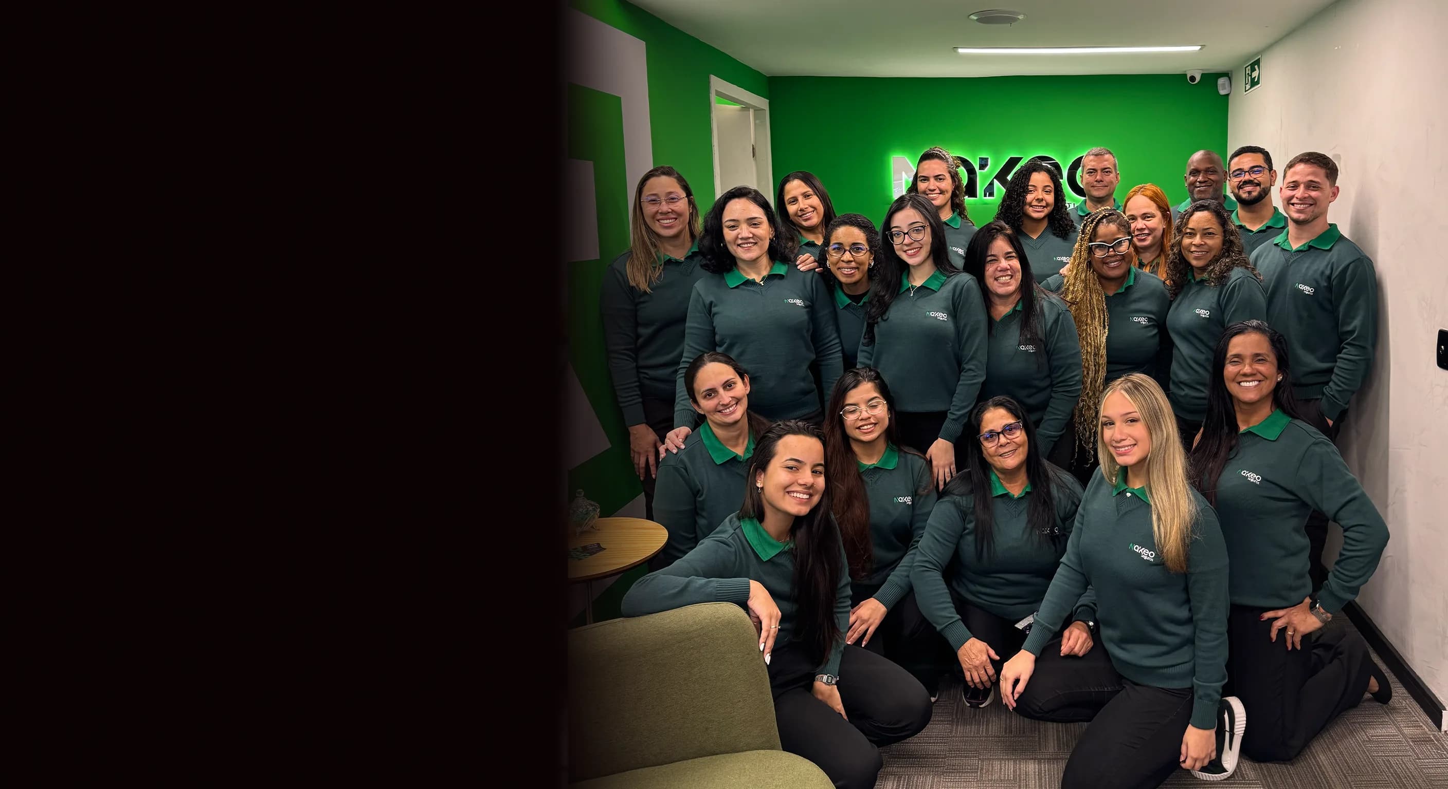 Equipe Nákeo reunida e sorrindo, com a logo da marca ao fundo